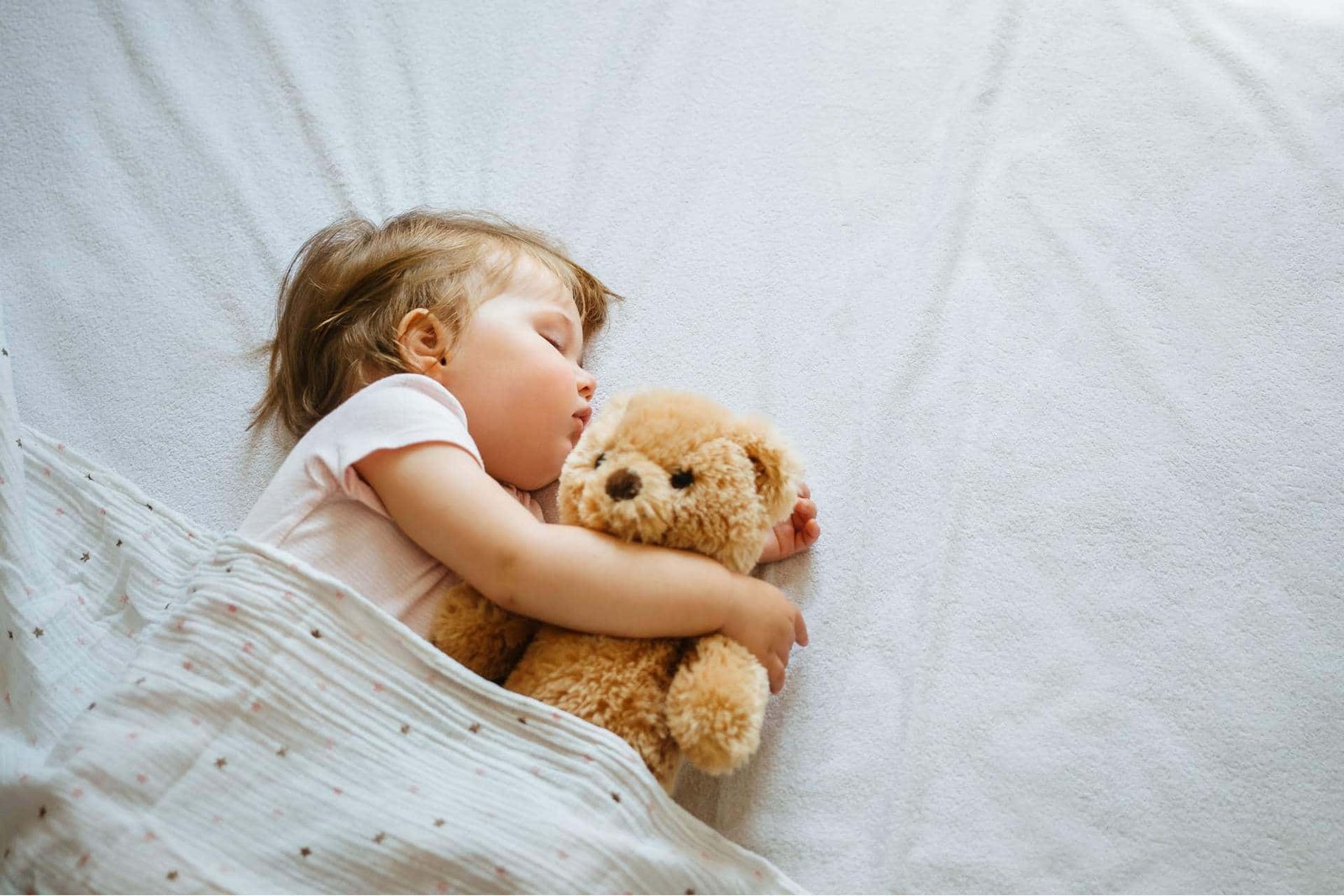 bébé endormi avec doudou illustrant l’effet apaisant des berceuses