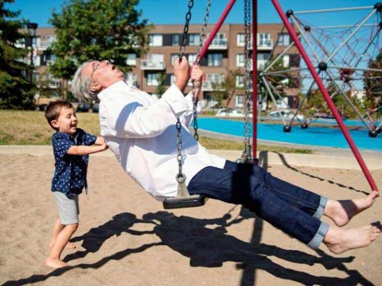 papa avec son enfant jouant à la balançoire
