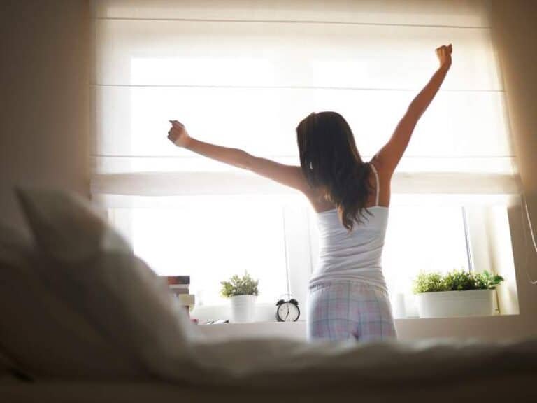 femme s’exposant à la lumière du soleil le matin