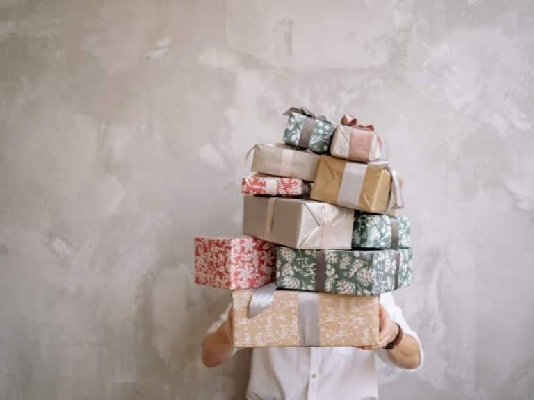 personne portant une pile de cadeaux illustrant le choix difficile